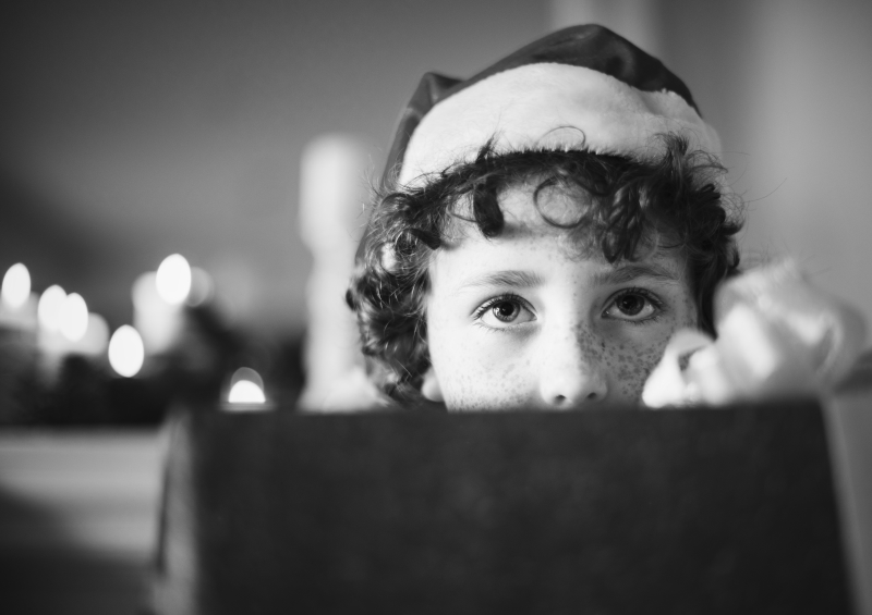 Child in a santa hat looking at the camera