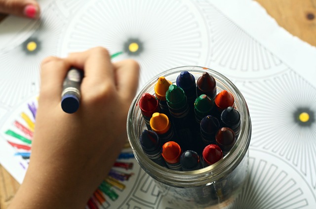 Pot of crayons and child colouring